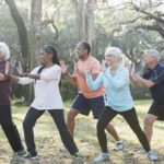 Diverse group doing tai chi outdoors.